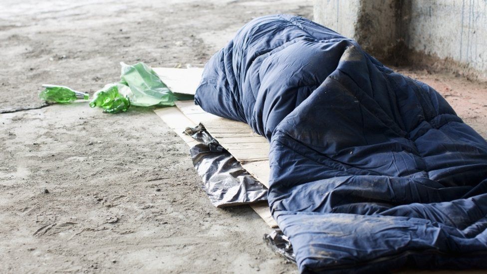A man sleeping rough on the streets.