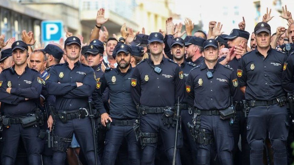 Spanish National Police officers stand outside their hotel as they face locals protesting against their presence in Pineda de Mar, north of Barcelona (03 October 2017)