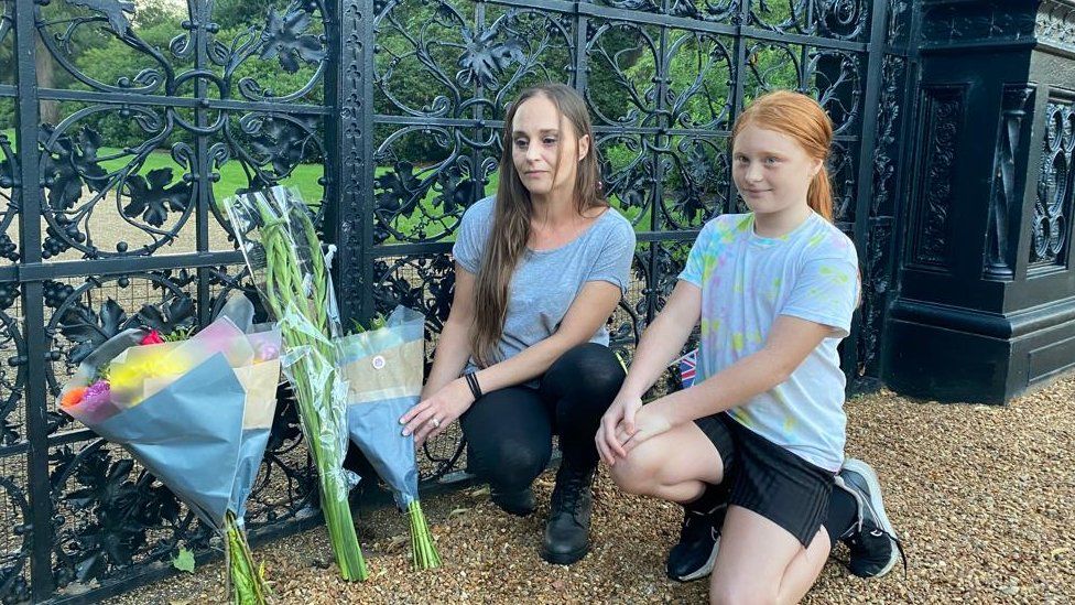Kelly Key and her daughter Jessica, 10 laying flowers outside the gates of Sandringham