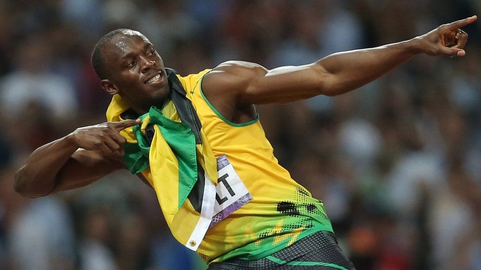 Download Usain Bolt Strikes Pose On Track Wallpaper | Wallpapers.com