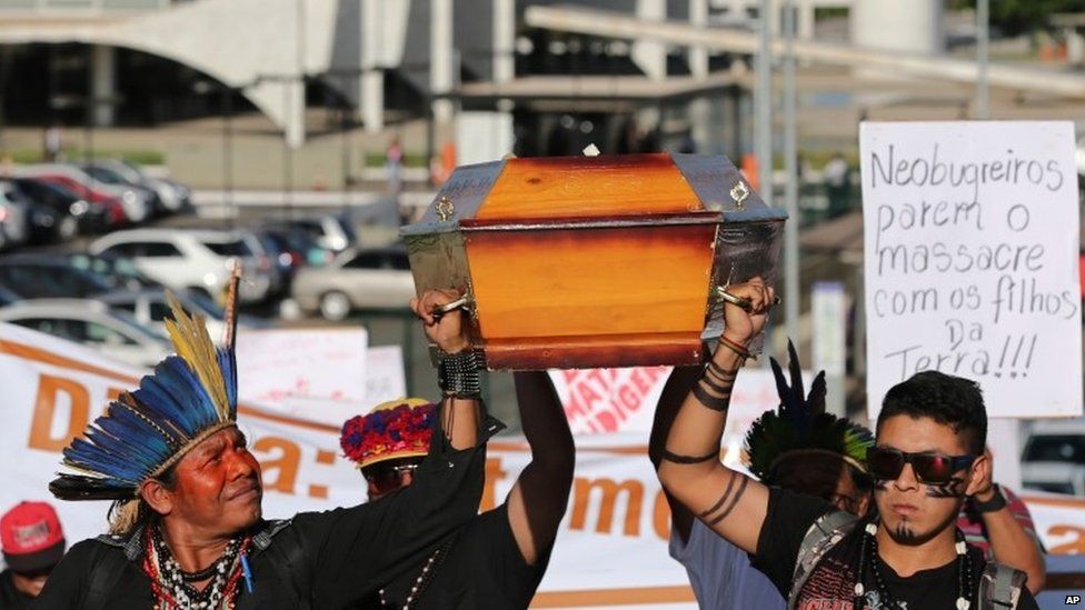 Indians of the Guarani Kaiowa tribe lift a coffin