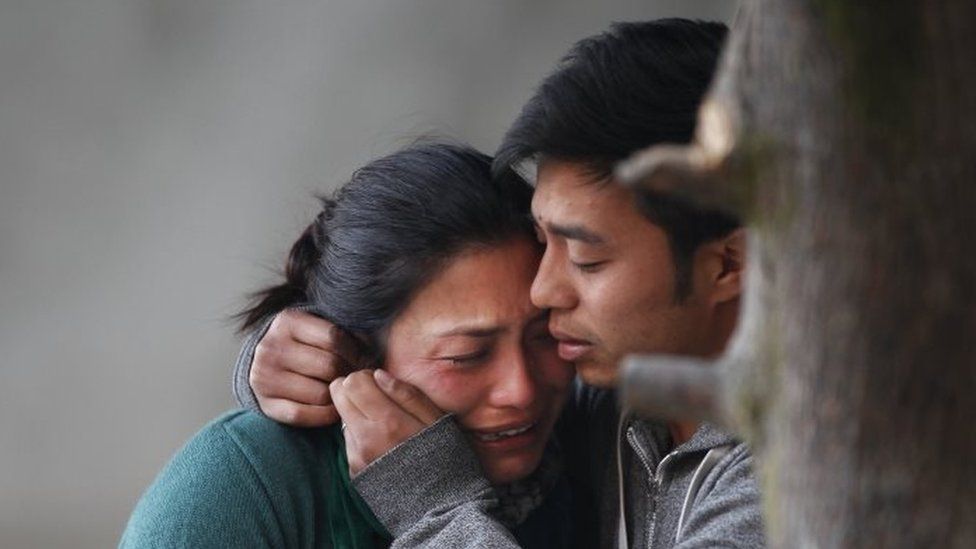 Family members of plane crash victims cry as they wait to receive their bodies in Kathmandu (25 February 2016)
