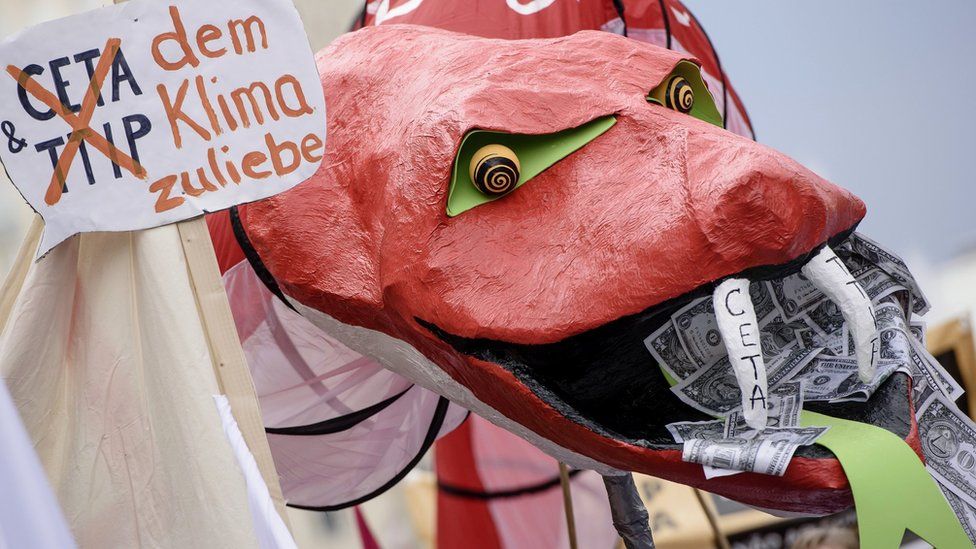 Protesters hold a giant snake with dollar notes in its mouth to demonstrate against the TTIP and CETA free trade agreements on Sept 17, 2016 in Berlin, Germany. The EU is currently negotiating with the US over TTIP and Canada over CETA