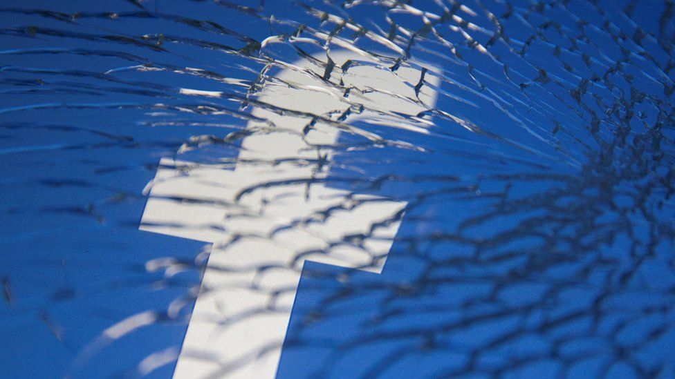 Facebook logo behind shattered glass