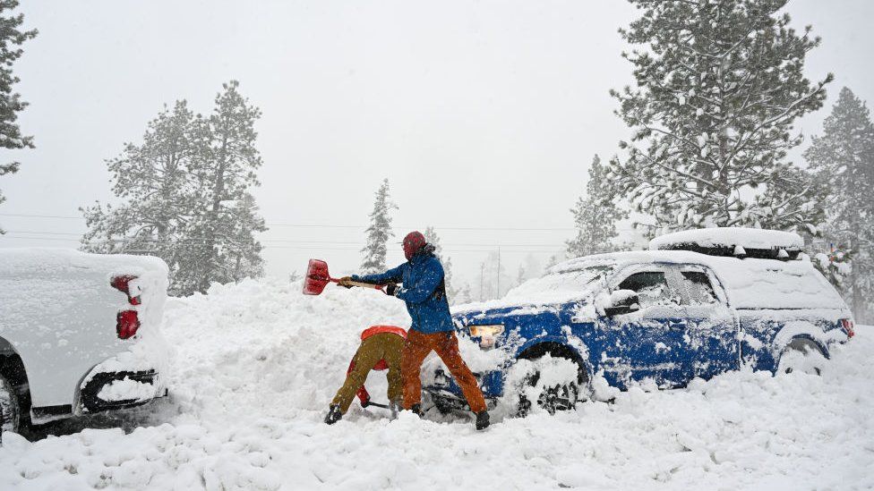 A man shovels snow in Sierra Nevada