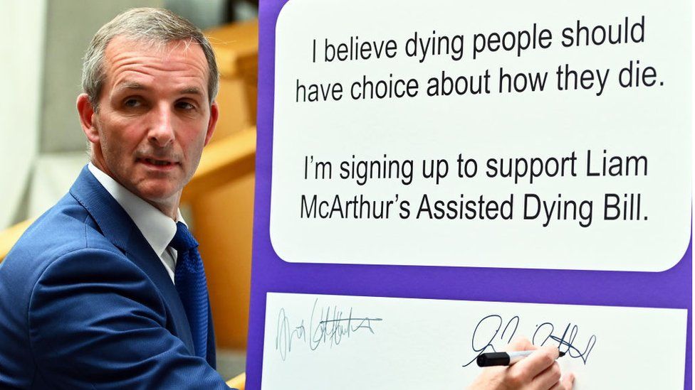 Scottish Liberal Democrat MSP Liam McArthur signs a board in the lobby of the Scottish Parliament for other MSPs to record their support for his Member's Bill on assisted dying,