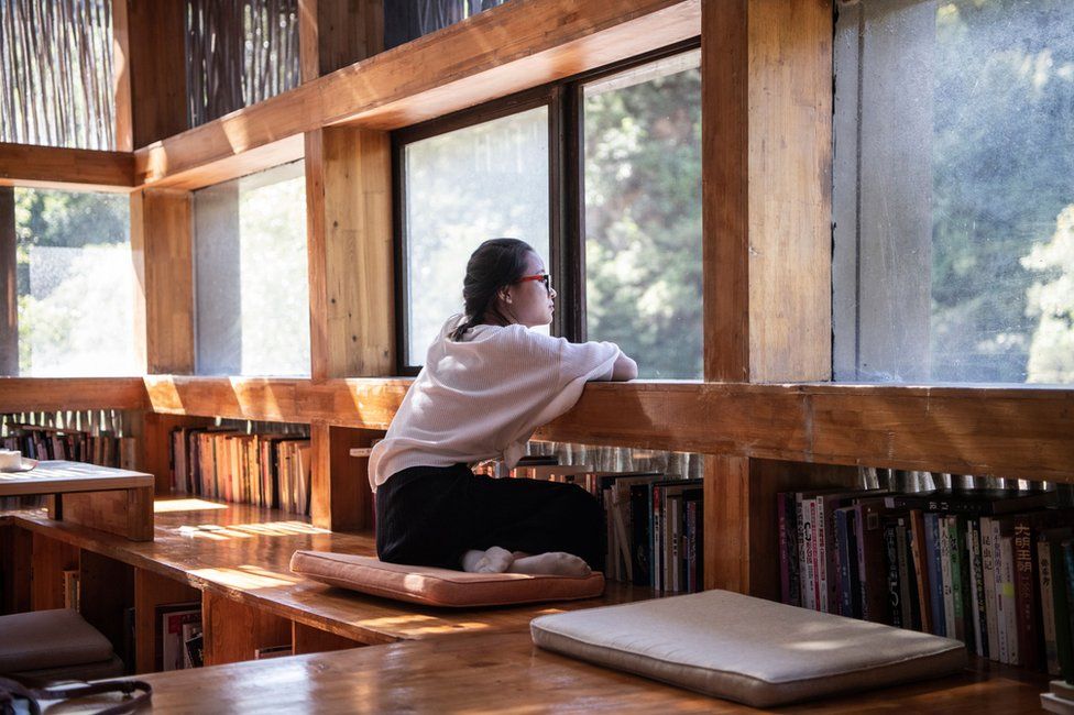 A woman looking out of a window in Liyuan Library