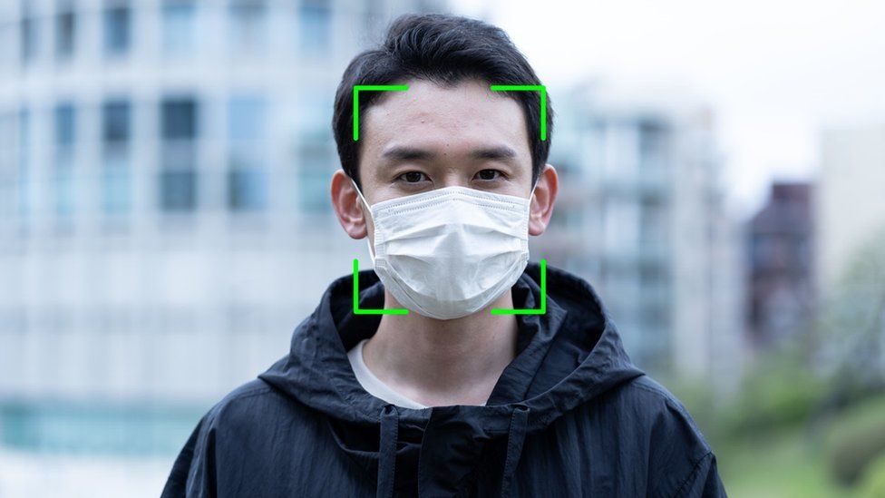 Man wearing a face mask with facial recognition overlayed