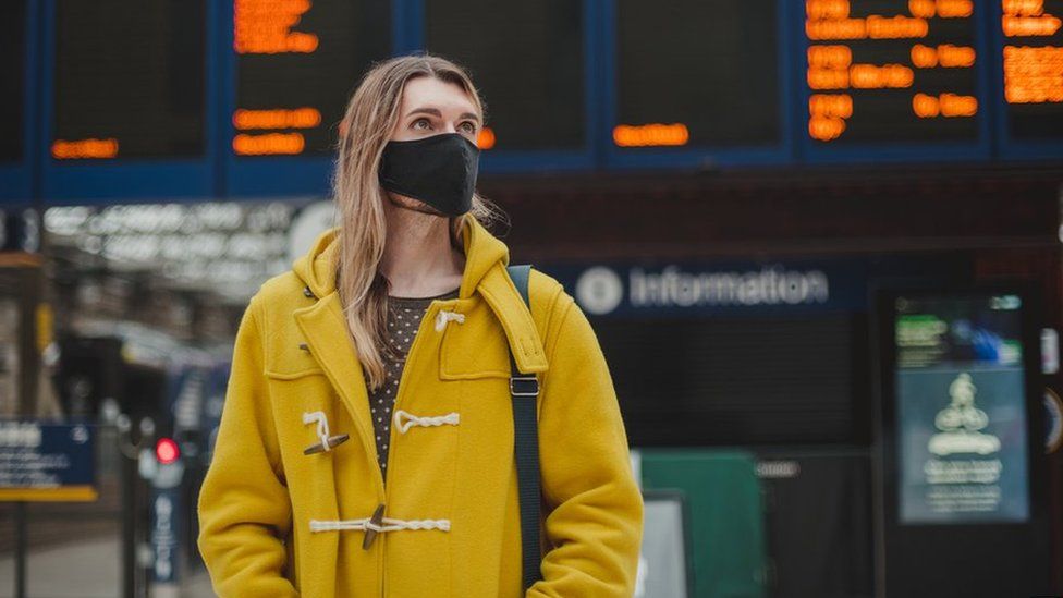 A woman waits at a train station