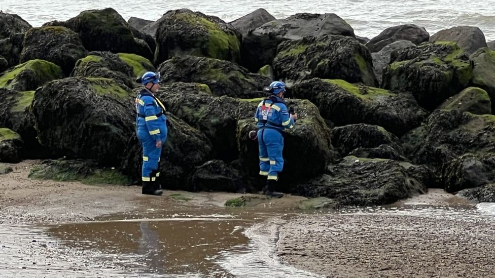 Clacton Coastguard Search and Rescue Team near rocks on the beach