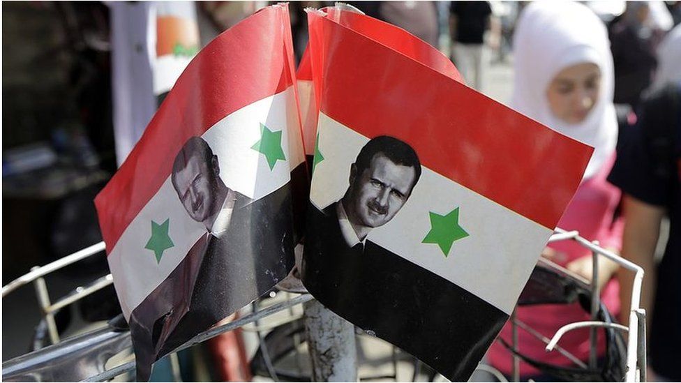 Syrian flags bearing President Assad's image (file photo)