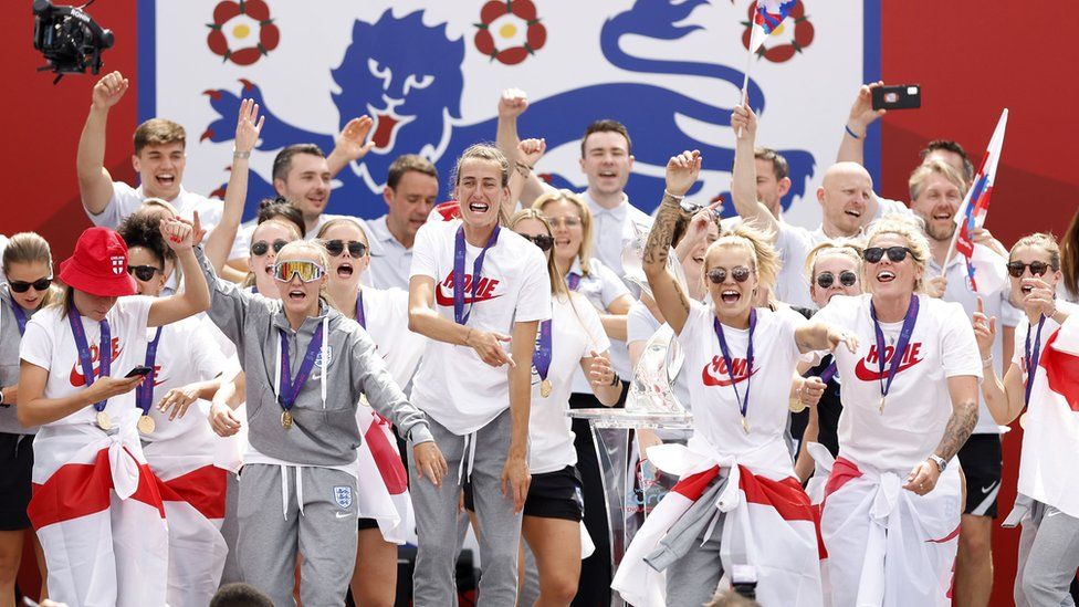 The England women's football team celebrate their Euros victory at London's Trafalgar Square in front of an England football icon