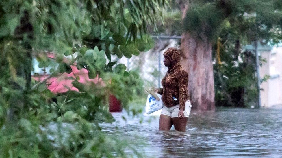 A woman walks in a flooded street after the effects of Hurricane Dorian arrived in Nassau, Bahamas