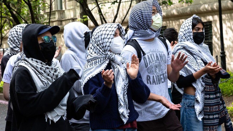 Pro-Palestinian protestors adjacent   an entranceway  to Columbia University connected  30 April 2024