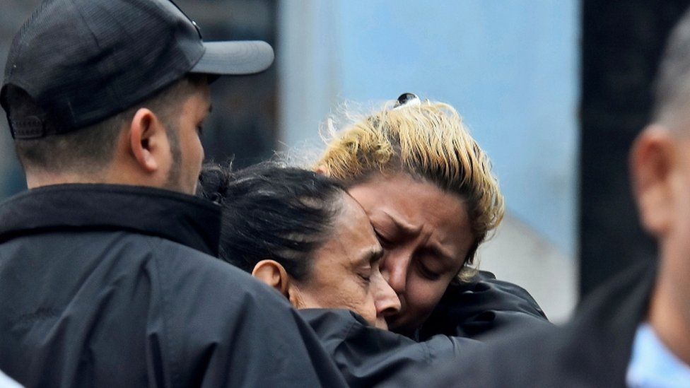 Relatives of a slain inmate mourn outside the prison after several inmates were killed or wounded during a fight between rival gangs, in Tela, Honduras December 21, 2019
