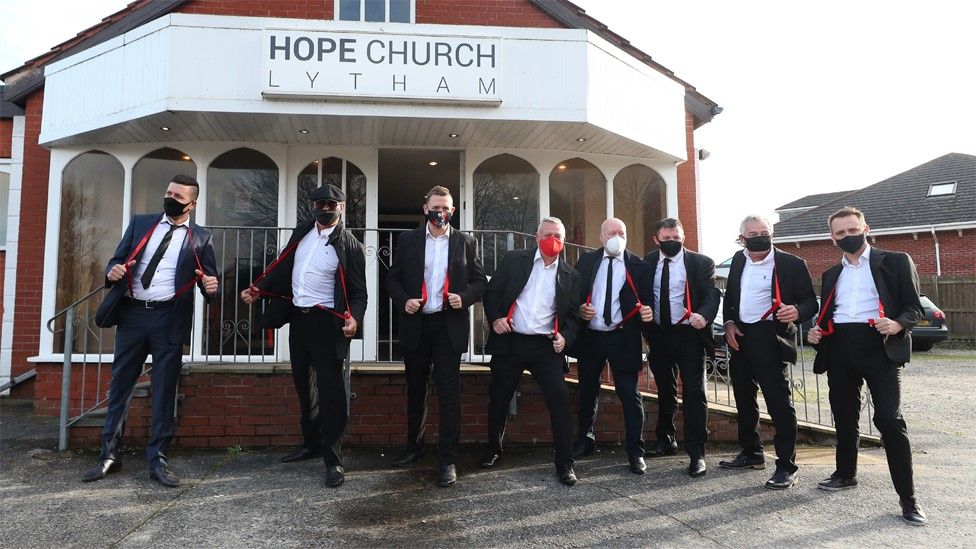 Mourners wearing red braces in honour of comedian Bobby Ball outside Hope Church in Lytham