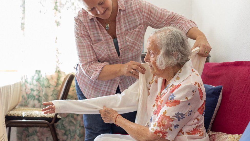 Mujer cuidadora y anciano en su casa