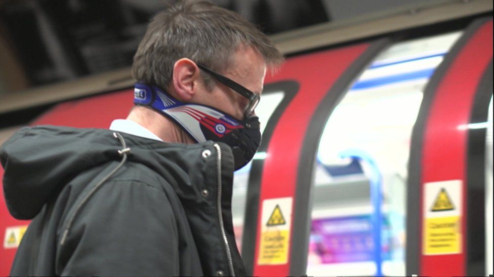 Man wearing a dust mask on Tube