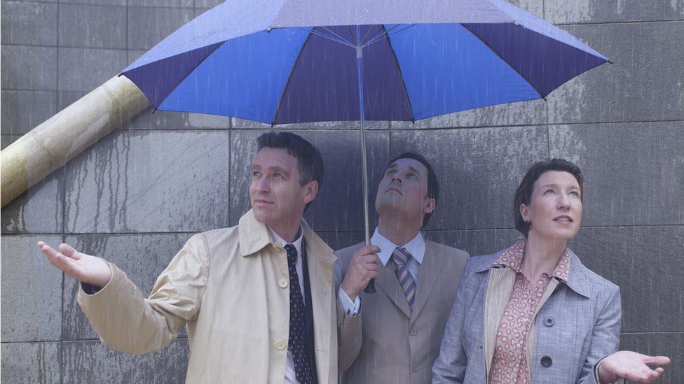 Men and women under umbrella in the rain