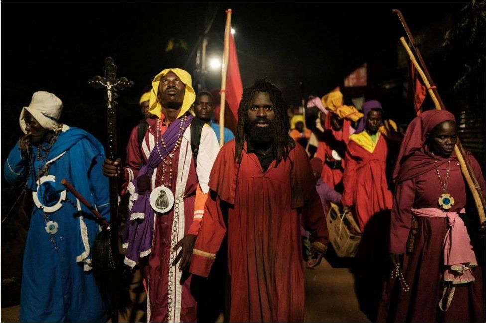 Worshippers of the Legio Mary walking on a procession overnight. They are wearing religious clothing and have rosaries and crucifixes.