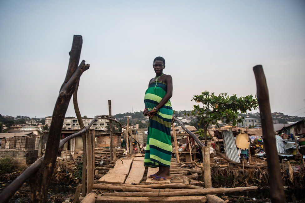 Isatu stands outside