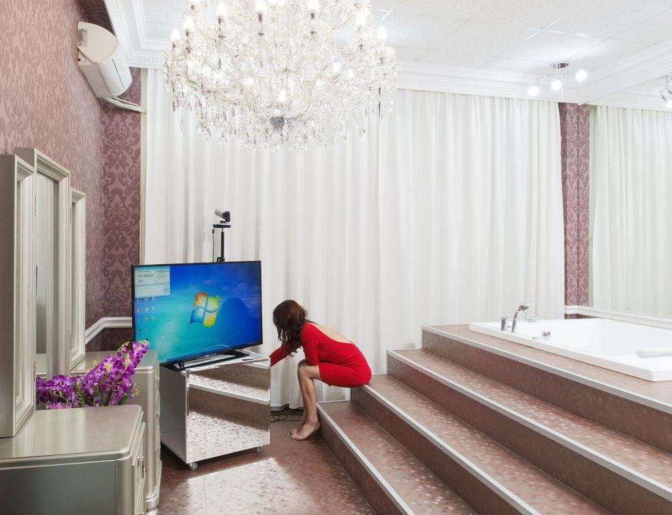 Joven en un baño frente a una gran pantalla de televisión