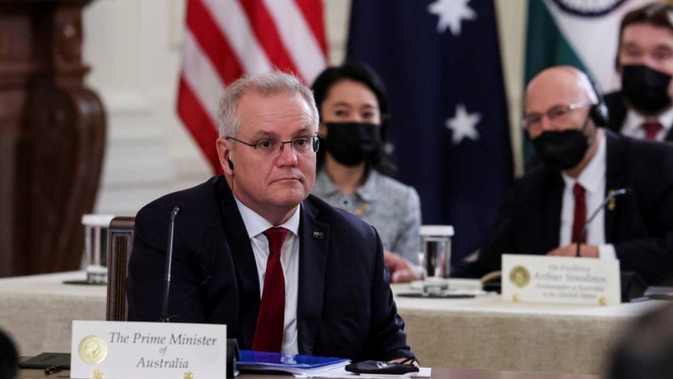 Australia"s Prime Minister Scott Morrison is seated with members of his delegation as he participates in a "Quad nations" meeting at the Leaders" Summit of the Quadrilateral Framework hosted
