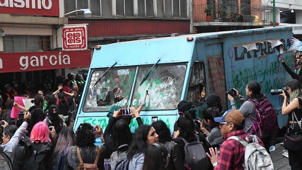 Demonstrators vandalize a press vehicle
