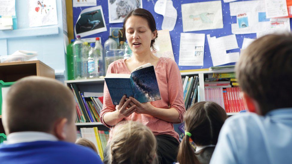 Teacher reading to children (stock image)