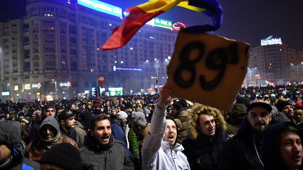 A man holds a placard reading '89' , the year of the Romanian uprising in 1989 which toppled late dictator Nicolae Ceausescu as people demonstrate in front of government headquarters against controversial decrees to pardon corrupt politicians and decriminalise other offenses on 31 January 2017 in Bucharest