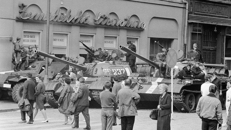 Russian tanks in Prague as locals walk by, August 1968.