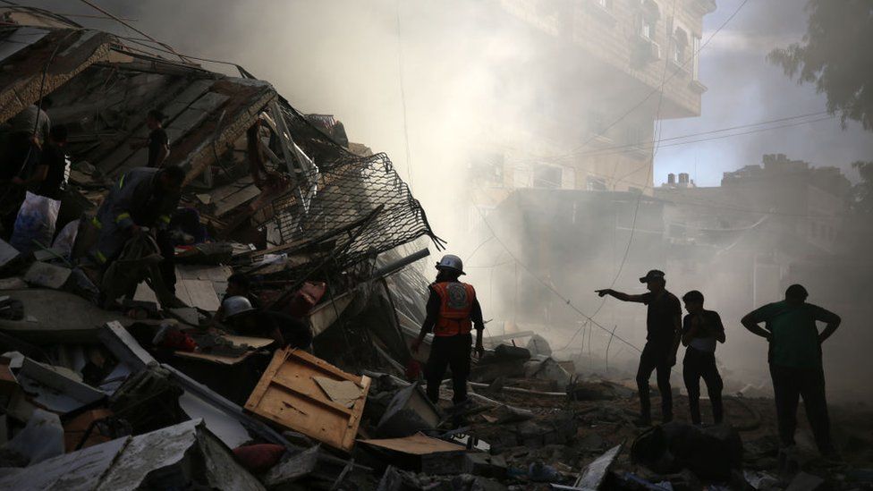 People assess the destruction caused by Israeli air strikes in Gaza City