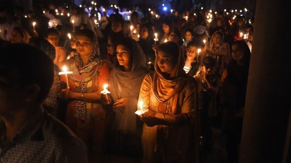 Pakistani Christian devotees holding candles while attending a Easter Vigil Mass at the Sacred Heart Church in Lahore.