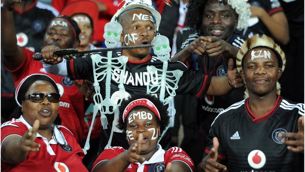 Supporters of South Africa's Orlando Pirates cheer before the first final of the 2015 CAF - Confederation of African Football Cup match with Tunisian Etoile du Sahel on 21 November 21, 2015 in Johannesburg.