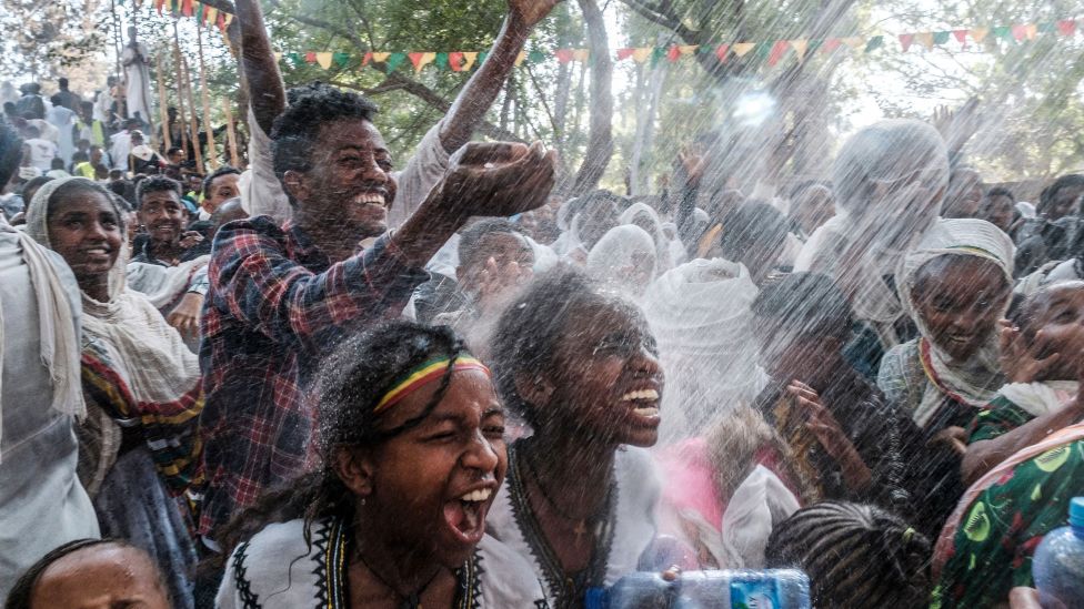 Orthodox Christians being sprayed with water at the Fasilides Bath in Gondar, Ethiopia - Wednesday 19 January 2022