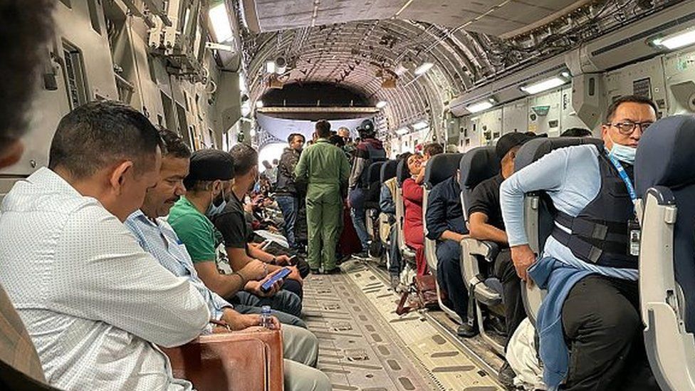 Indian nationals sit aboard an Indian military aircraft at the airport in Kabul on August 17, 2021 to be evacuated after the Taliban stunning takeover of Afghanistan