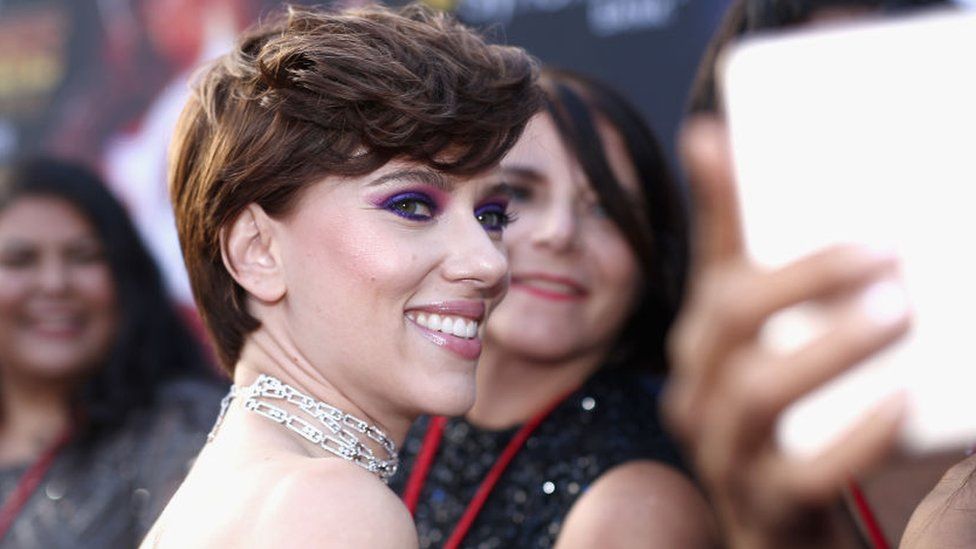 Scarlett Johansson smiling on the red carpet for fans at the Avengers: Infinity War premiere in Los Angeles