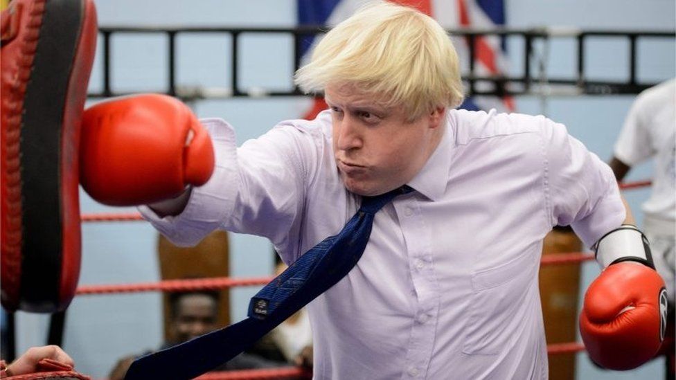Boris Johnson hitting a punch bag with boxing gloves