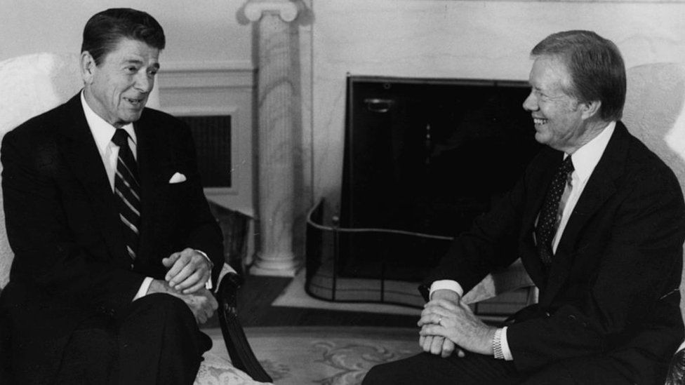 President Ronald Reagan (left) talks to former President Jimmy Carter at a meeting regarding the AWACS sale of planes to Saudi Arabia, in the Oval Office of the White House, Washington DC, October 13th 1981