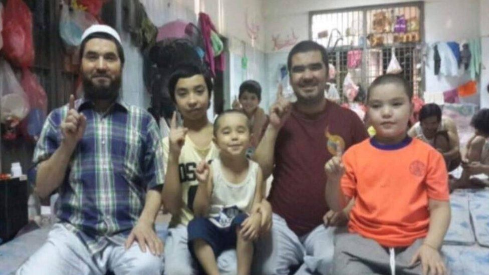 Азиз Абдулла (бордовая футболка) и семья перед бегством в Таиланд.
