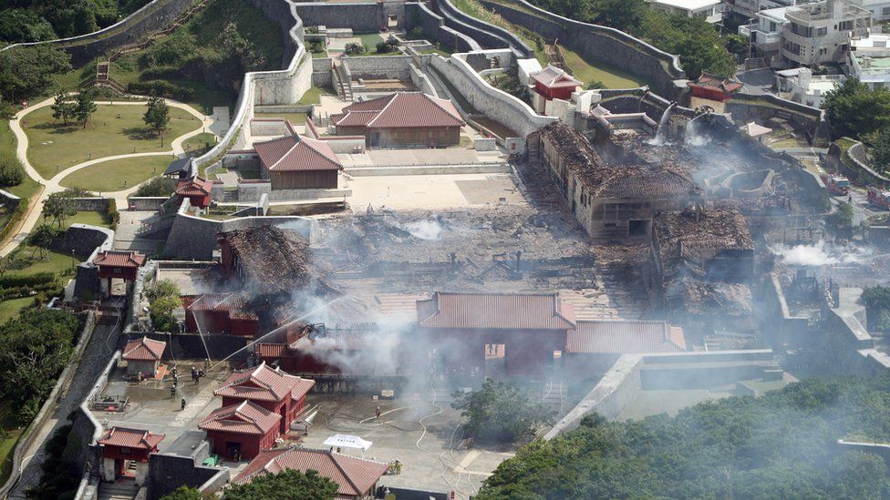 An aerial photograph shows the destroyed Shuri Castle in Naha