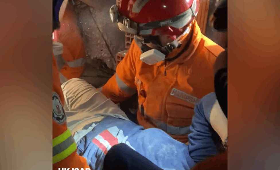 Screengrab from video dated 11/02/23 of a police officer and a woman from the rubble of a building in Hatay, Turkey, five days after the country was devastated by an earthquake.