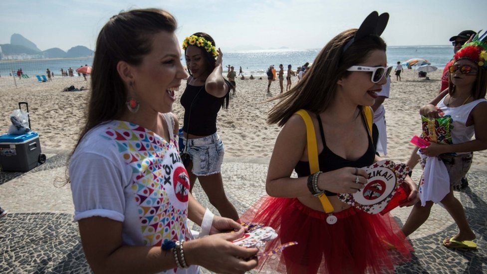 Government employees in Copacabana Beach hand out leaflets with information about Zika