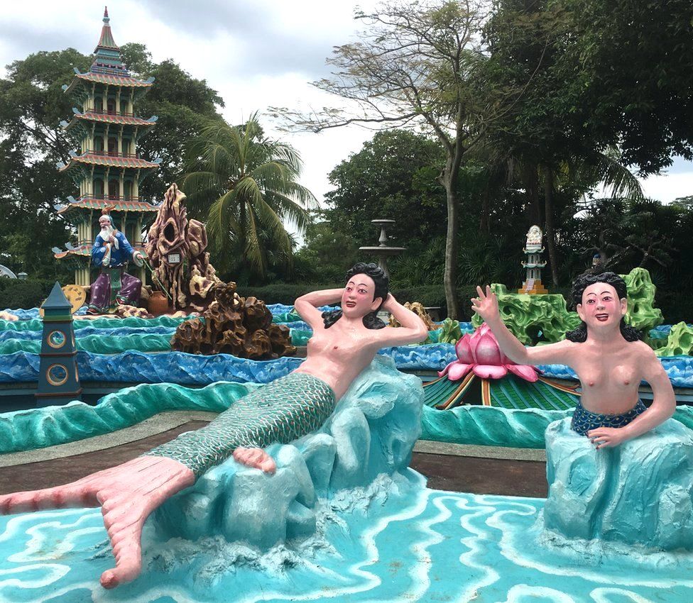 A cluster of brightly coloured life-sized topless mermaid statues at Singapore's Haw Par Villa