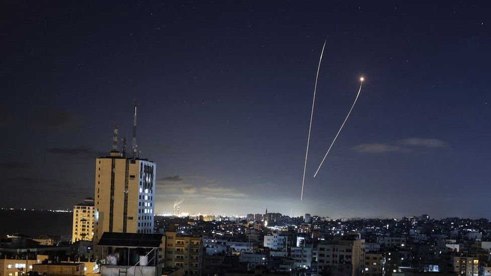 Полоса света появляется, когда израильская противоракетная система Iron Dome перехватывает ракеты, запущенные из сектора Газа 18 мая 2021 года.