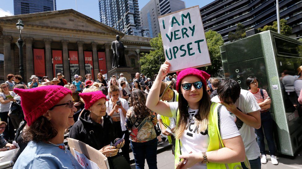 Woman holding sign saying 'I am very upset' as protesters take part in the Melbourne rally to protest against the Trump Inauguration on January 21, 2017
