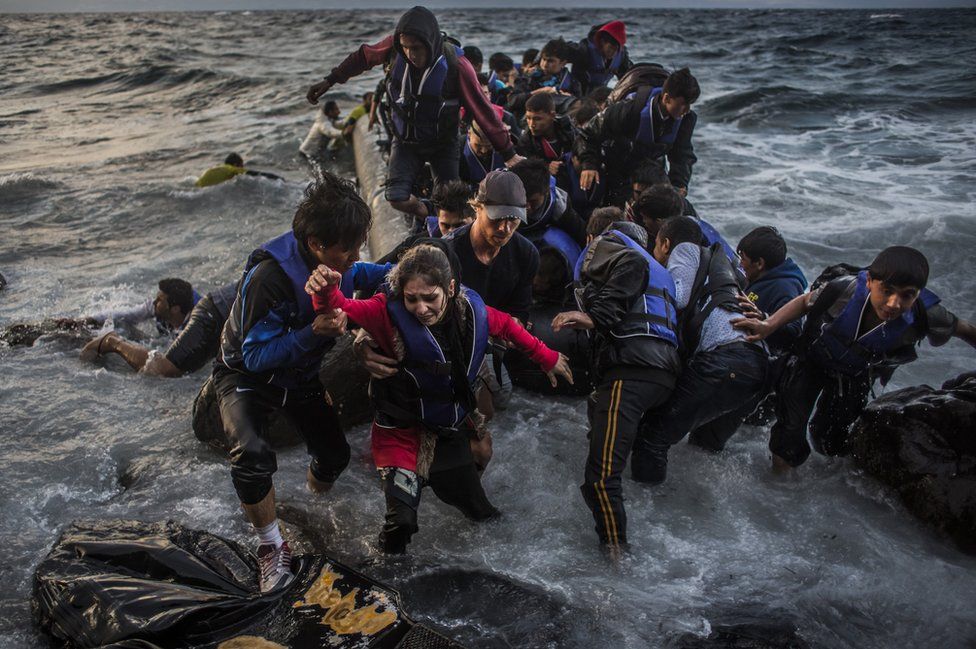 Refugees arrive on the shores of the Greek island of Lesbos after crossing the Aegean sea from Turkey on an inflatable boat, 1 October 2015