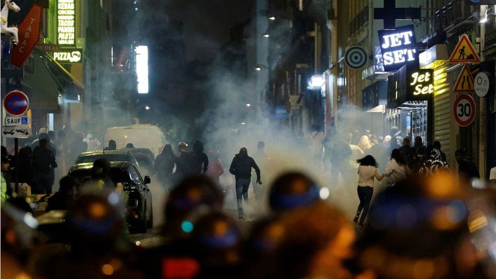 Участники беспорядков убегают, поскольку французские полицейские применяют слезоточивый газ в Париже 2 июля