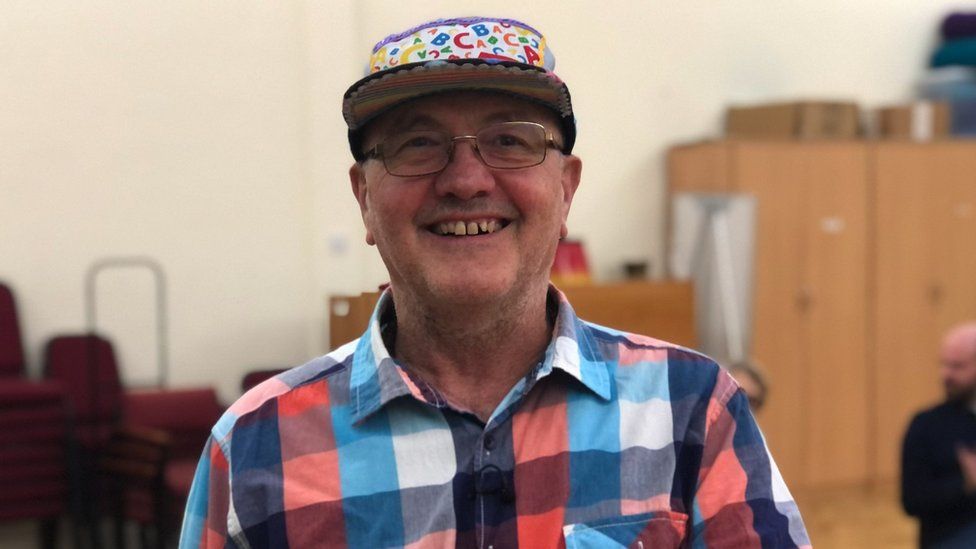 Joe Hoare wearing a plaid shirt and a colourful cap