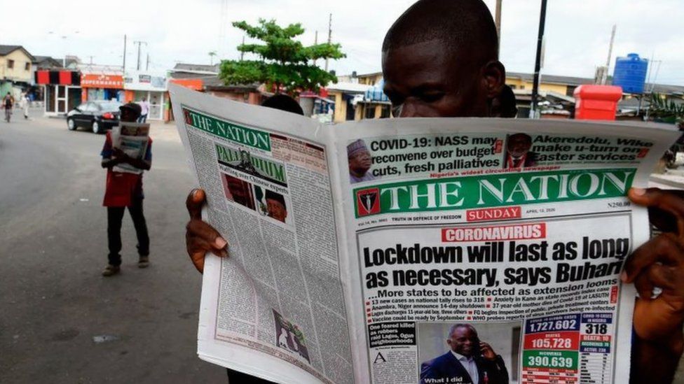 Man reading newspaper in Lagos street